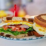 Breakfast Sandwich with eggs, sausage cheese, tomato and lettuce with cheese on rye