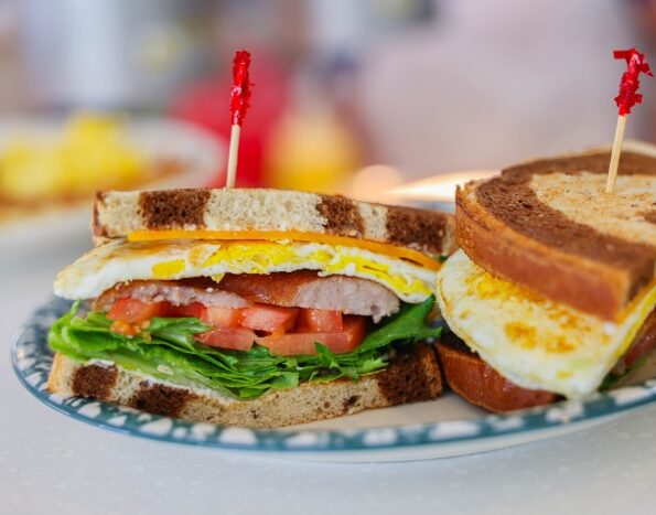 Breakfast Sandwich with eggs, sausage cheese, tomato and lettuce with cheese on rye